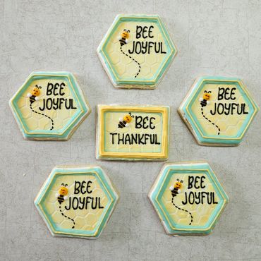 Hexagonal and rectangular bee-themed plaques with positive messages.