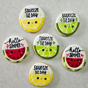 Colorful citrus and watermelon-themed cookies with summer sayings.