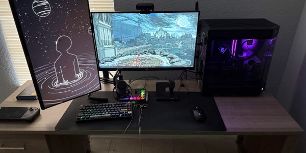 Minimalistic gaming and streaming setup with dual monitors and purple lighting.