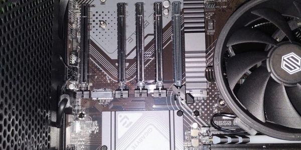 Inside view of a computer motherboard with expansion slots and a CPU cooler.