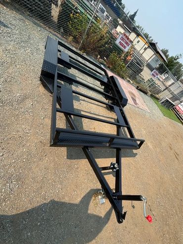 Black metal trailer frame on gravel.