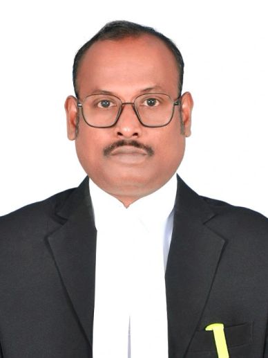 Professional portrait of a man in legal attire with glasses.