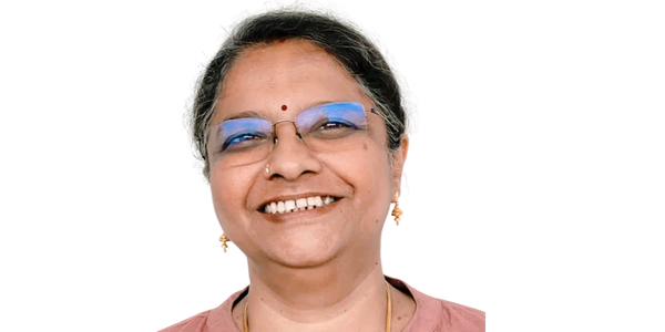 Smiling middle-aged woman wearing glasses and a pink top.