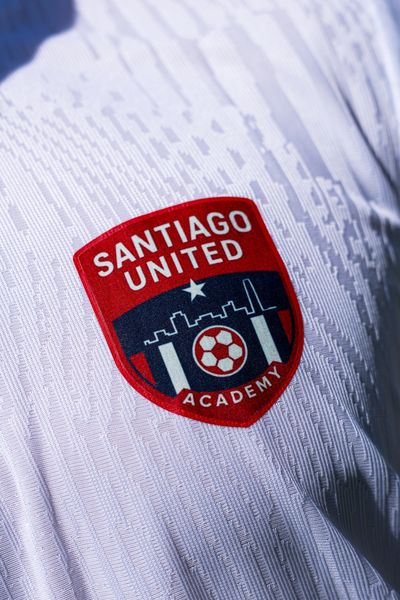 Close-up of a Santiago United Academy soccer jersey badge.