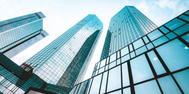 Modern glass skyscrapers reaching into the blue sky.