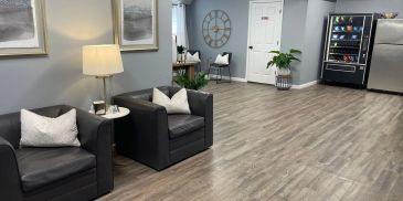 Modern lounge with black chairs and vending machines.