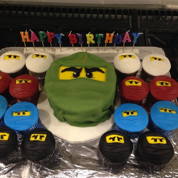 Ninjago birthday cake and cupcakes on a tray with birthday candles