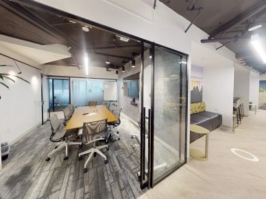 Modern glass-walled conference room with chairs and table.
