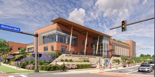 Modern school building with glass and brick exterior on a sunny day.