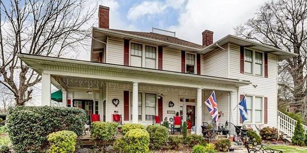 The Inn of the Patriots featured in a full-color photo featuring bushes and trees around the mansion