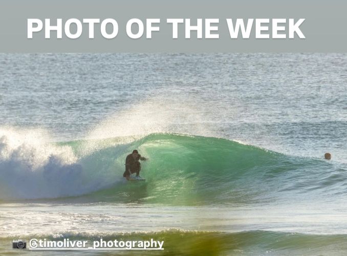 Surfer riding a wave with 'Photo of the Week' text.
