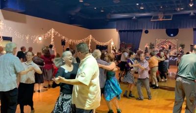 A group of people dancing in a decorated hall.