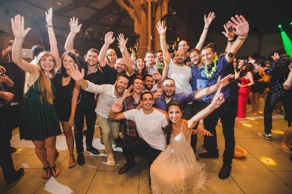 Group of friends joyfully posing with raised hands at a lively party.