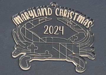 Clear acrylic ornament in the shape of a crab with the Maryland flag design. It says "Maryland Chris
