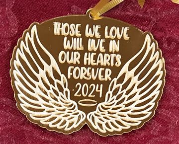 Gold mirrored ornament in the shape of angel wings. Says "Those we love will live in our hearts fore