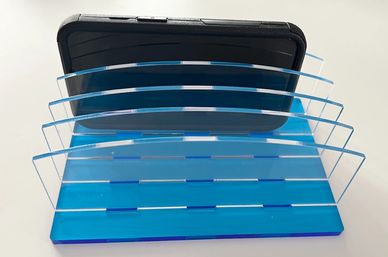 A device charging station with clear vertical dividers and a blue topaz base.