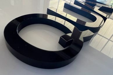 Close-up of black letters on a reflective surface.