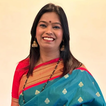 Smiling woman in traditional Indian saree with jewelry.