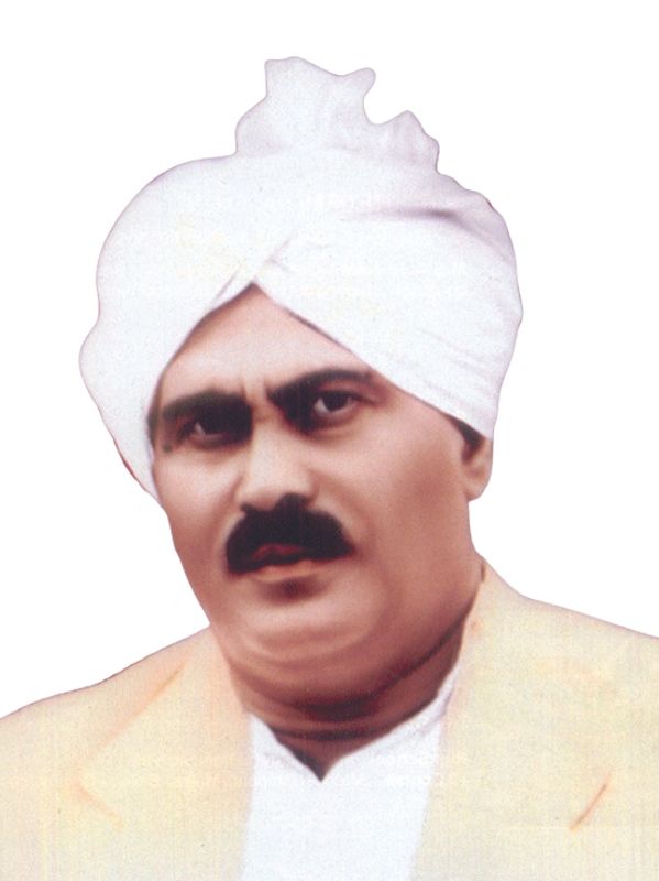 Man wearing a white turban and beige coat.