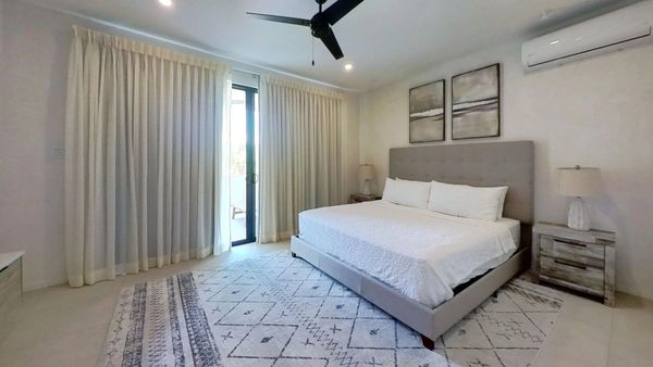 Bright bedroom with king-size bed and beige accents.