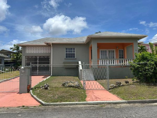 Single-story house with gray and orange exterior under a blue sky.