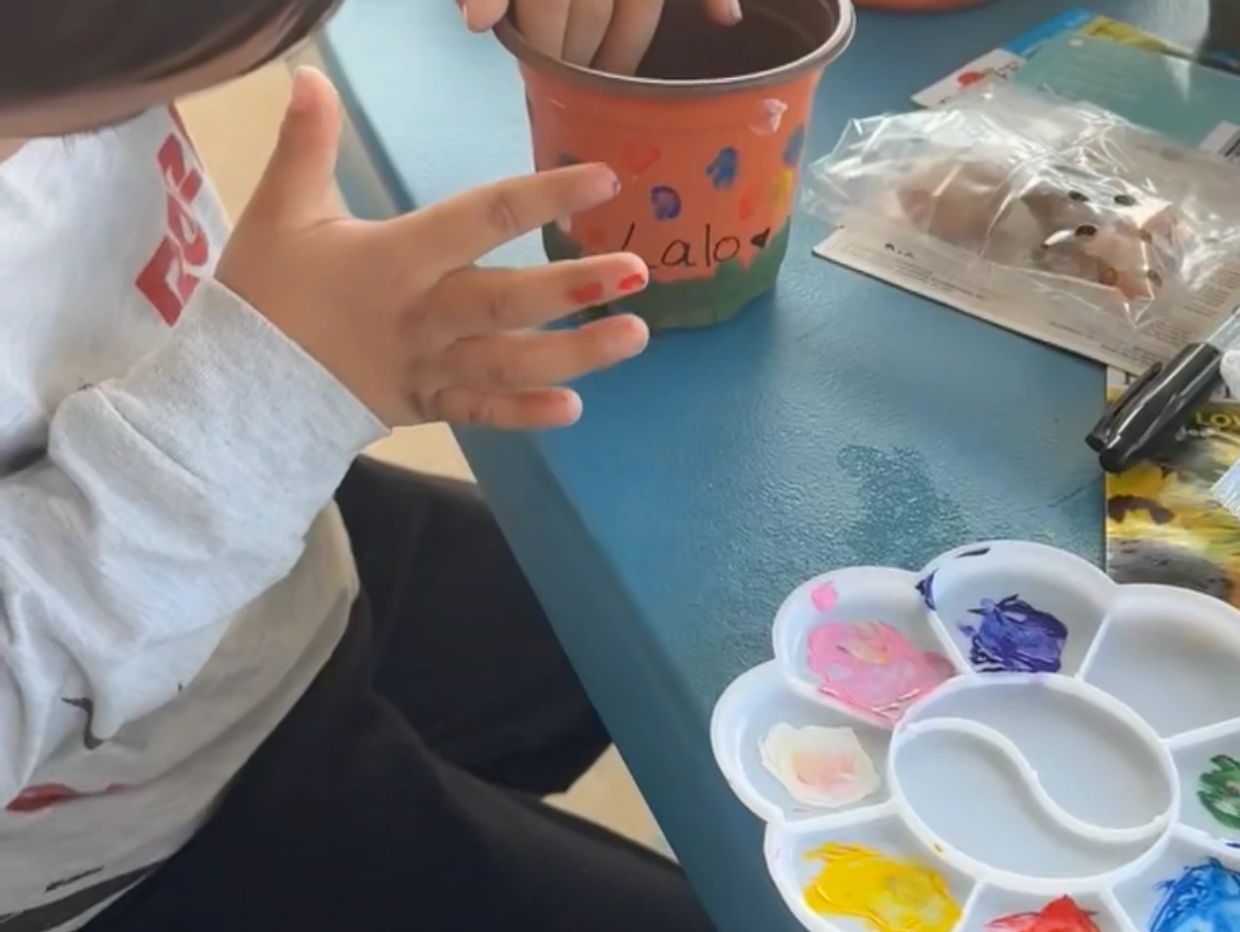 Child participating in a hand-painting activity at our child care center in Houston TX 77090.