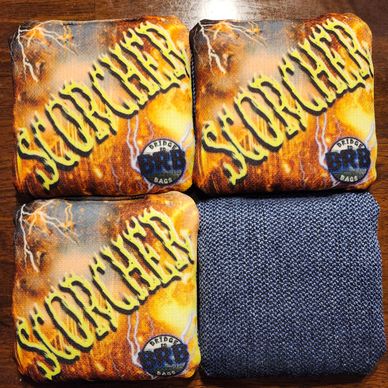 A close-up of a yellow and orange pouch with 'SCORCHER' text and a blue textured fabric beside it.