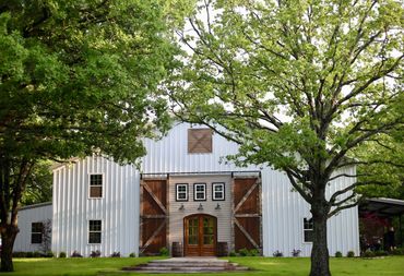 Outdoor wedding barn venue with trees in the country.