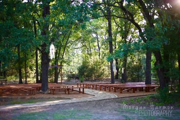 Wooded outdoor ceremony venue area. Wood benches. Stone path isle. Beautiful  oak trees.