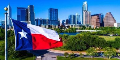 Texas flag waving with city skyline.