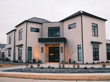 Modern two-story house with large windows and a clean exterior.