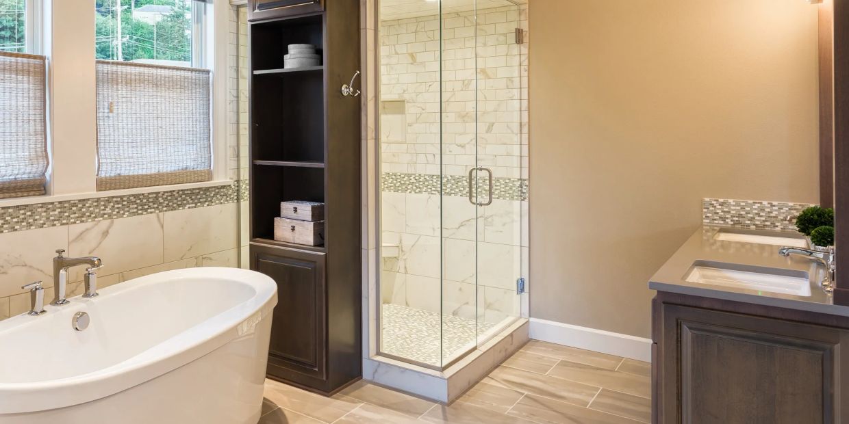 Modern bathroom with bathtub, glass shower, and double sink vanity.