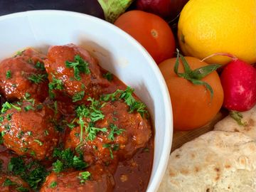 Arabic spiced meatballs with a tangy fresh tomato sauce served with freshly baked flat breads 