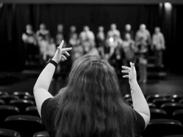 Directora con grupo en ensayo teatral.