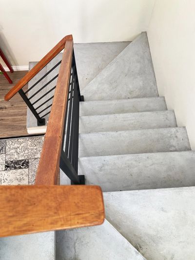 Top-view-concrete-staircase-wood-handrail-and-powder-coated-black-steel-balustrade