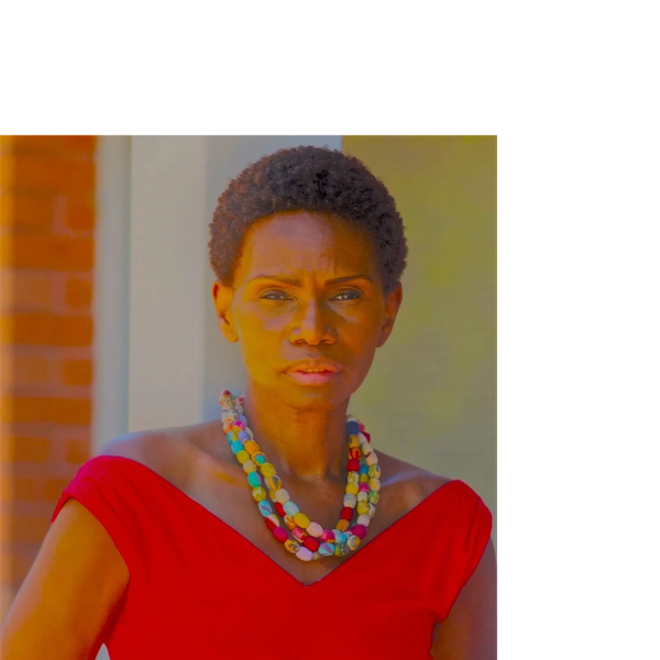 Confident woman in a red dress with colorful necklace.