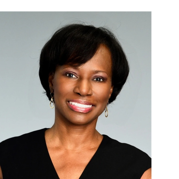 Smiling woman with earrings and short hair.