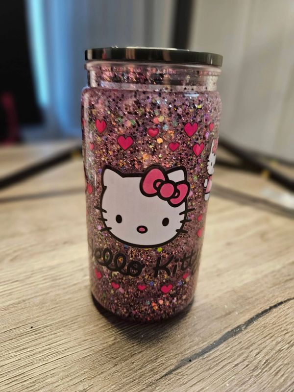 Hk snow globe cup with pink and black glitter.