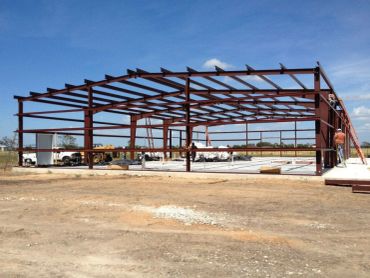 Steel frame structure under construction on clear day.