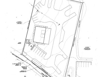 Site plan showing building, parking, and road layout with topographic lines.