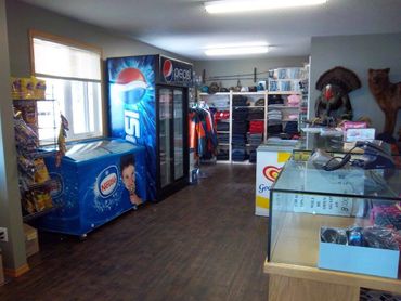 Small store interior with snacks, beverages, clothing, and taxidermy decorations.