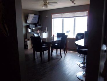 Dining area with dark furniture and large window lighting.