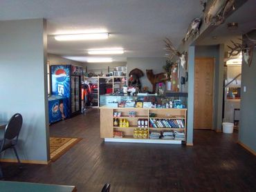 Interior of a rustic store with a counter, shelves, and mounted animal trophies.