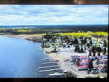A lakeside village with docks and red-roofed buildings.