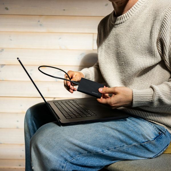 Person connecting external hard drive to a laptop.
