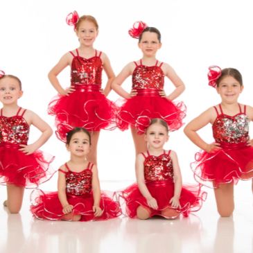 Young girls in red dance costumes posing.