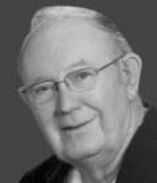 Portrait of an elderly man wearing glasses, smiling gently.