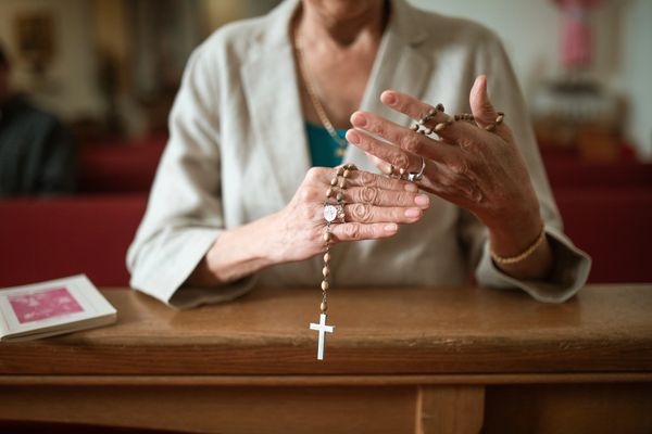 Woman praying with a rosary 