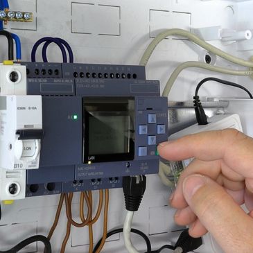 Close up of a hand setting up a PLC. Testing and programming of an industrial control system.
