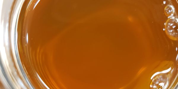 Close-up of a glass filled with amber liquid and bubbles.